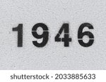 Black Number 1946 on the white wall. Spray paint. Number one thousand nine hundred forty six.