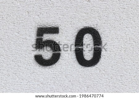 Black Number 50 on the white wall . Spray paint.