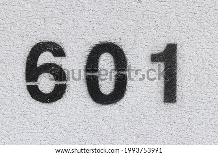 Black Number 601 on the white wall. Spray paint. Number six hundred one.