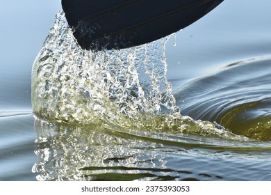 black oar in green river water closeup - Powered by Shutterstock