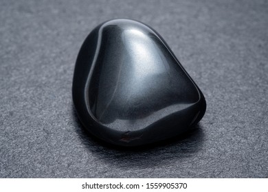 Black obsidian on a dark background - Shutterstock ID 1559905370