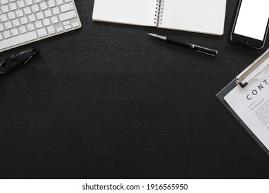 Black Office Wooden Desk Table With Computer, Tablet, Mobile Phone, And Office Supplies - Table Top View With Copy Space