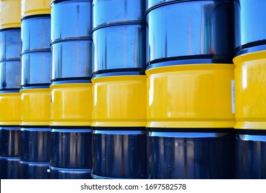 Black oil barrel. Petroleum drum containers. Gasoline barrels background. Crude mining concept and graph of falling oil prices on the trading exchange. Crude oil pump jack at oilfield.