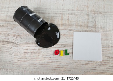 Black Oil Pouring Out Of A Barrel On A Wooden Background