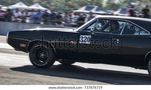 a black\
and old dodge charger speeding on circuit during a motor show in\
italy. italy-rivanazzano terme 15 october\
2017
