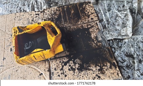 Black Old Oil Of Car Motor Engine Used Spill Drop On The Floor. An Old Comforter Is On The Garage Floor To Catch Stray Drips.