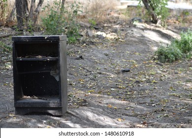 Black Old Weathered Desk Without Drawers In The Middle Of Nowhere In A Light Forest.