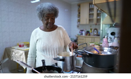 A Black Older Woman Cooking At Kitchen Stirring Pot