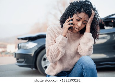 Black Oman Making A Phone Call After Having A Car Crash