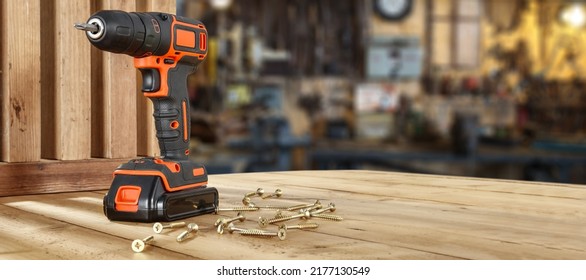 Black and orange drill and wooden desk of free space for your decoration. Workshop interior.  - Shutterstock ID 2177130549