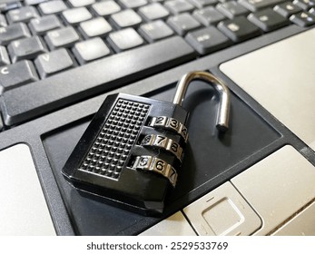 Black padlock key with numeric code on black computer keyboard. Computer security concept.