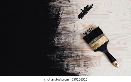 Black Paint And Brush On A Wood Background