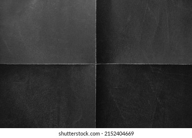 Black paper background with creases that separates paper symmetrically into four parts