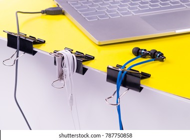 Black paper clips DIY life hack for organizing usb cables and headphones on a work place