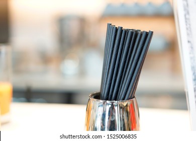 Black paper straw in the stainless cup at the restaurant bar. It's the choice for reduce the plastic waste because It's biodegradable waste to save the animal and world from plastic waste.