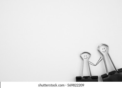 Black paperClip and smile face   people holding hands white paper  Love Couple Concept