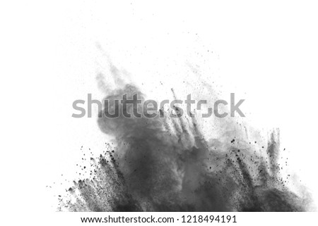 Black particles splatter on white background. Black powder dust exploding.
