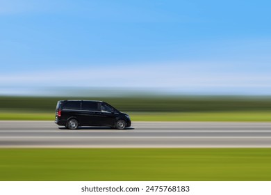 Black passenger minibus, minivan is driving on the street with blurred background at speed. Car with passenger transportation concept and free space for text, copy space. Taxi, transfer shuttle.