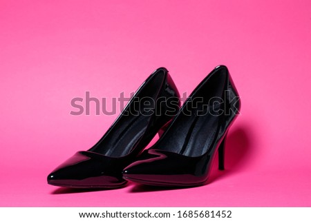 Black patent leather pumps on a colored background