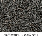 Black pebble stones or charcoal pebbles as decorative material on landscape garden or park, pebbles are good choice for modern contemporary garden floor.