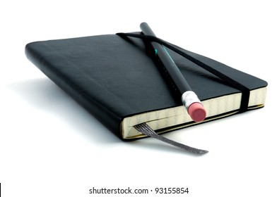 Black pen with pink rubber on black leather moleskin notebook isolated on white.