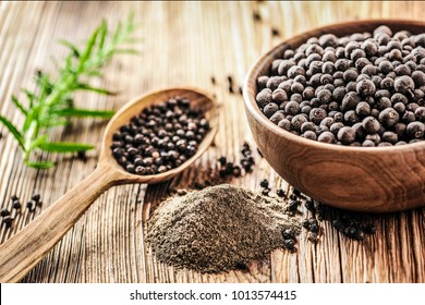 Black pepper in bow on wooden table. Pile of ground black pepper. - Shutterstock ID 1013574415