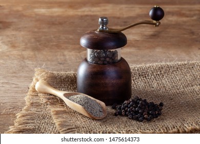 Black Pepper And Pepper Grinder On Wooden Floor