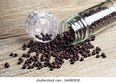 Black Pepper And Grinder For Spices On Wooden Table