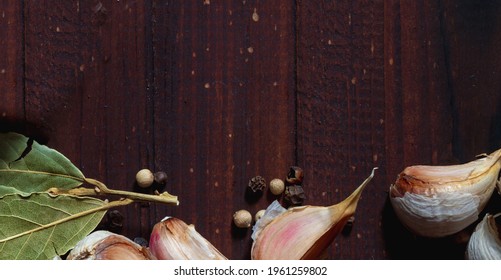 Black Pepper Peas, Bay Leaf, Garlic For Making Marinade On A Brown Wooden Background.