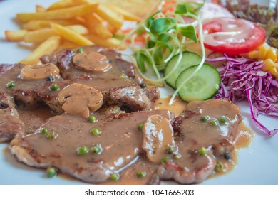 Black Pepper Steak In Dish With Tomato, French Fries, And Portobello Mushroom In Sauce Gravy.