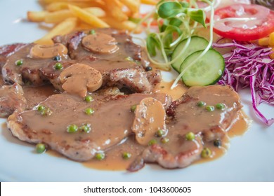 Black Pepper Steak In Dish With Tomato, French Fries, And Portobello Mushroom In Sauce Gravy.