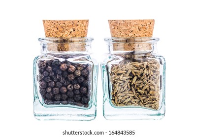 Black pepper and white cumin spices in a small corked glass bottles. - Powered by Shutterstock