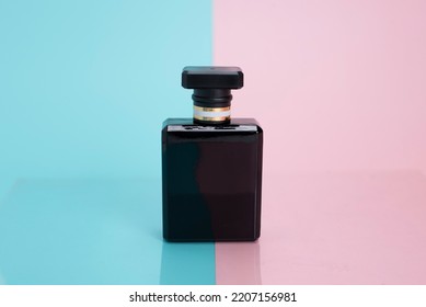 black perfume bottle on blue and pink background - Shutterstock ID 2207156981