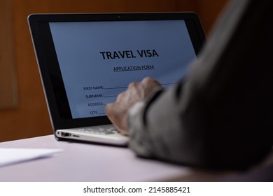 Black Person Filling Travel Visa Application On A Computer