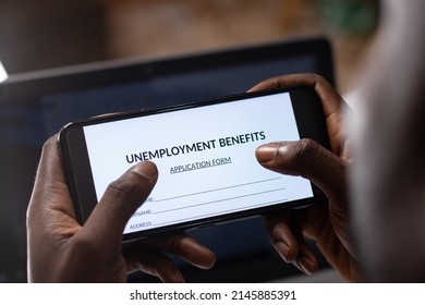 Black Person Filling Unemployment Benefit Form On A Phone