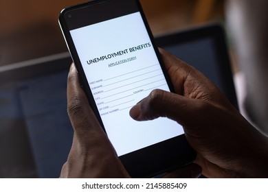 Black Person Filling Unemployment Benefit Form On A Phone