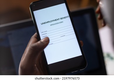 Black Person Filling Unemployment Benefit Form On A Phone