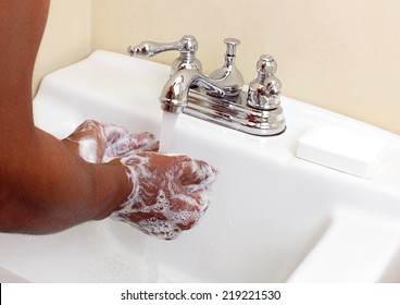 Black Person Washing Hands With Soap Under Running Water