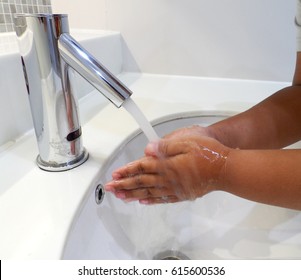 Black Person Washing Hands With Soap Under Running Water