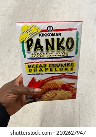 A Black Person's Hand Holds A Box Of Kikkoman Panko Bread Crumbs In A Grocery Store