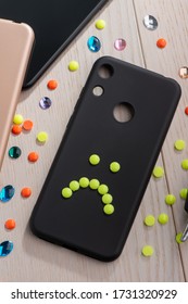 Black Phone Case Decorated With Yellow Sad Smile. Unhappy Mood, Creative DIY Project.