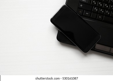 Black Phone And A Laptop On A White Background
