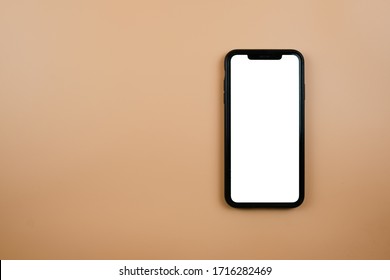 Black Phone On An Orange Background. Top View. Flat Lay.