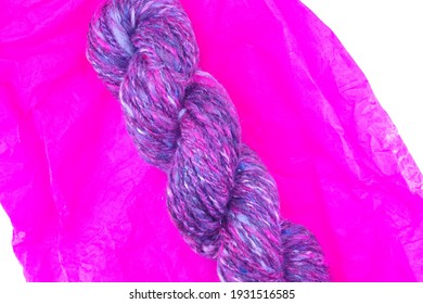Black, Pink, Red, Purple, And Grey Variegated Hand Spun Yarn On Pink Tissue Paper - Seen From Above