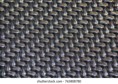 Black plastic basketwork pattern in close-up, process of weaving