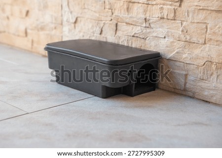 Black plastic box with bait inside used for outdoor rodent control against pests