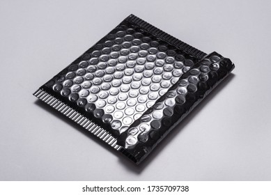 Black plastic bubble envelope on grey background