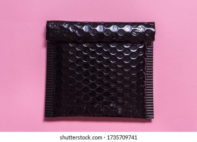 Black Plastic Bubble Envelope On Pink Background