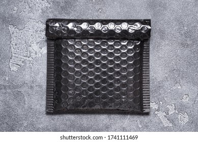 Black Plastic Bubble Envelope On Grey Background