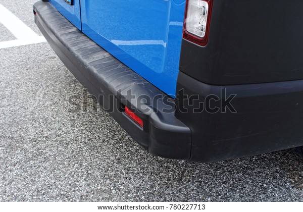 Black plastic bumper, rear view of blue van,\
cracked rear bumper